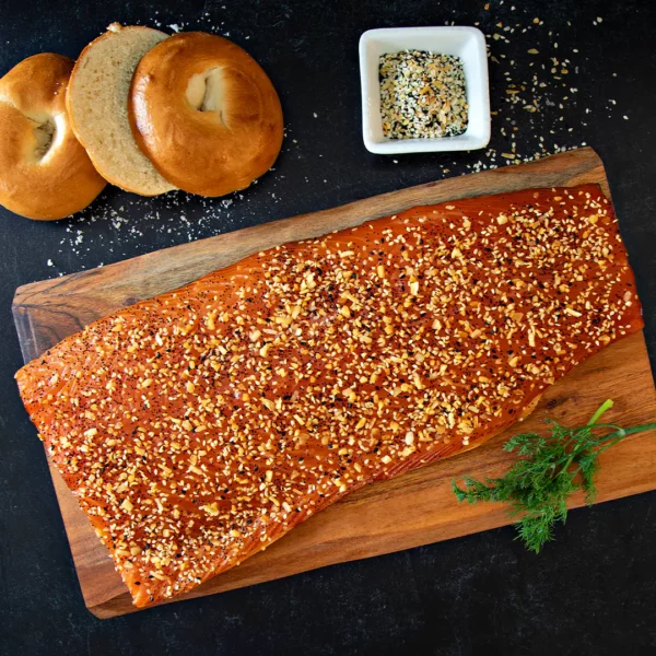everything lox full side on cutting board with bagel and seasoning